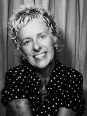 a black-and-white image of Michelle Bernard, a woman in a polka-dot shirt smiling at the camera